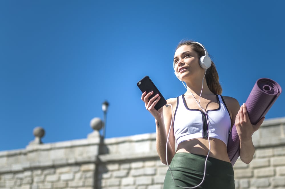 women walking to the park to do yoga wearing midrange earphones